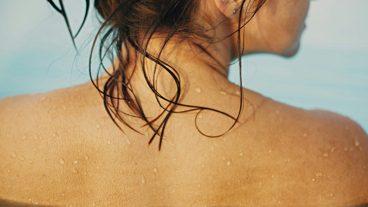 Mulher relaxando após um banho de lua, com a pele iluminada e hidratada para um efeito dourado suave.