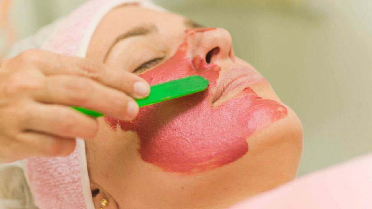 Mulher recebendo um tratamento de esfoliação corporal, removendo células mortas para uma pele mais macia e renovada.